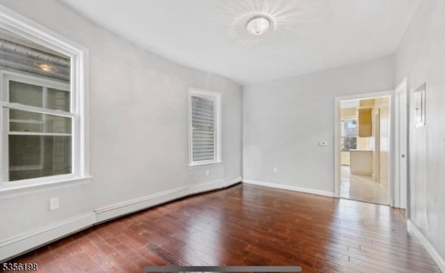 spare room with hardwood / wood-style flooring and baseboards