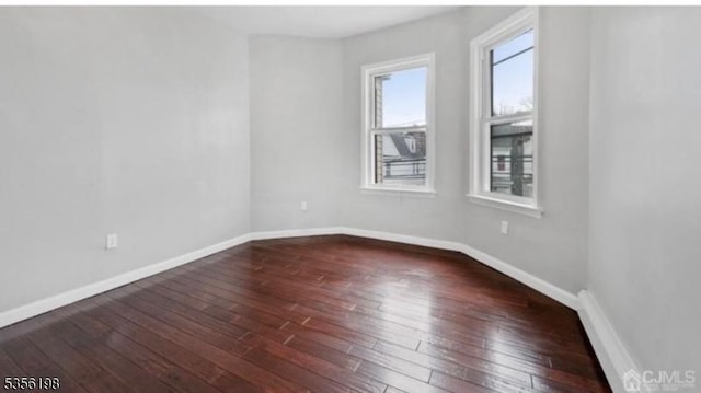 empty room featuring hardwood / wood-style floors and baseboards