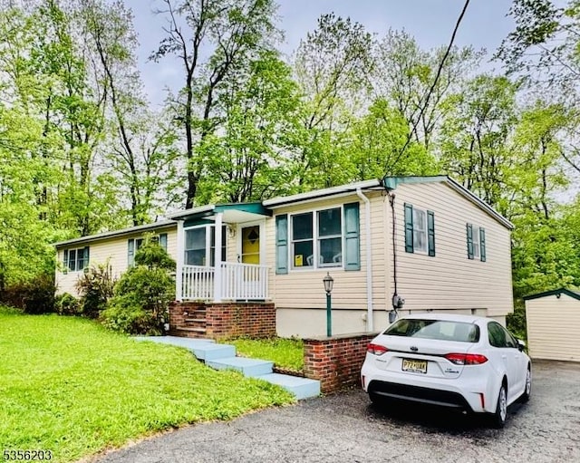 4 Burgher Rd, Vernon Twp, NJ 07422 - view of front of home with a front yard, asphalt driveway, a garage, and view of wooded area