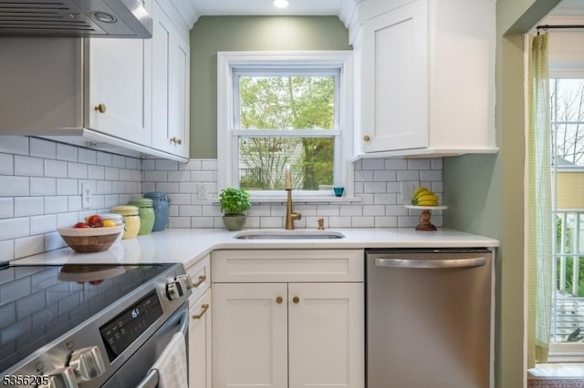 kitchen featuring appliances with stainless steel finishes, extractor fan, white cabinetry, and a sink