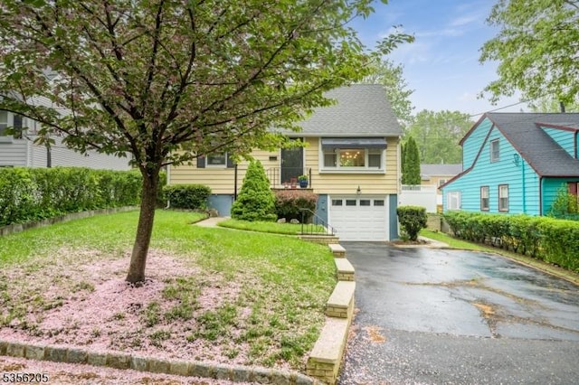 view of front of home featuring driveway, an attached garage, and a front yard