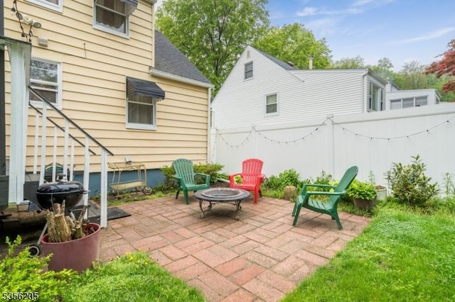 view of patio with fence and a fire pit