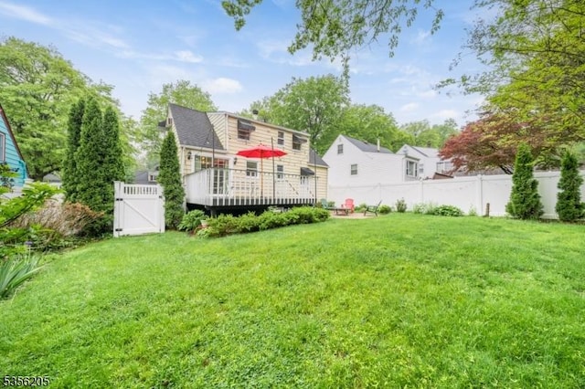 rear view of property with a wooden deck and a gate