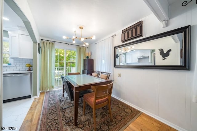 dining area with a chandelier, light wood finished floors, and baseboards
