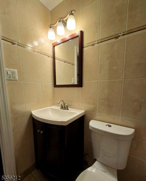 899 Robin Rd Unit 899, Hillsborough Twp, NJ 08844 - half bathroom featuring tile walls, vanity, and toilet