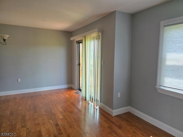 899 Robin Rd Unit 899, Hillsborough Twp, NJ 08844 - empty room featuring healthy amount of natural light, hardwood / wood-style flooring, and baseboards