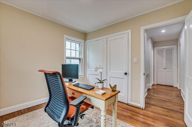office featuring baseboards, light wood-style flooring, and crown molding