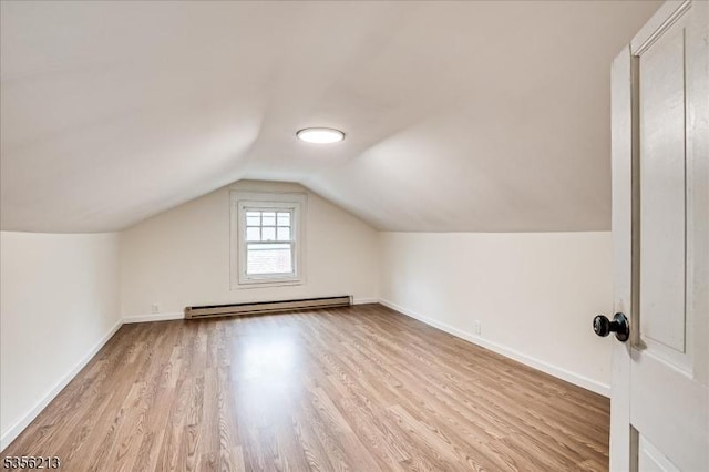 additional living space with baseboard heating, wood finished floors, baseboards, and lofted ceiling