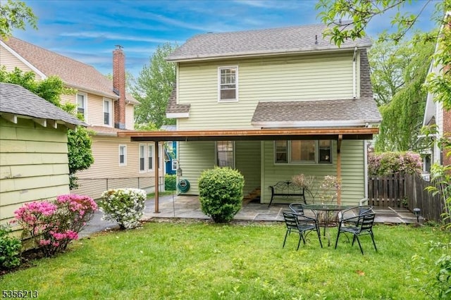 back of property featuring a patio and roof with shingles