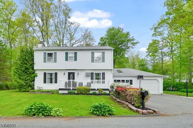 colonial inspired home with a garage, driveway, a chimney, and a front lawn