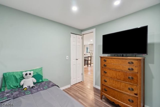 bedroom with wood finished floors, baseboards, and recessed lighting