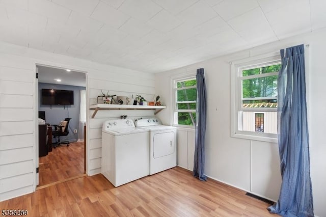 washroom with separate washer and dryer and light wood-style flooring