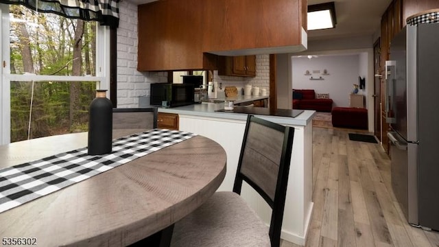 6 Longview Ln, Vernon Twp, NJ 07461 - kitchen with black appliances, light wood finished floors, brown cabinetry, a peninsula, and light countertops