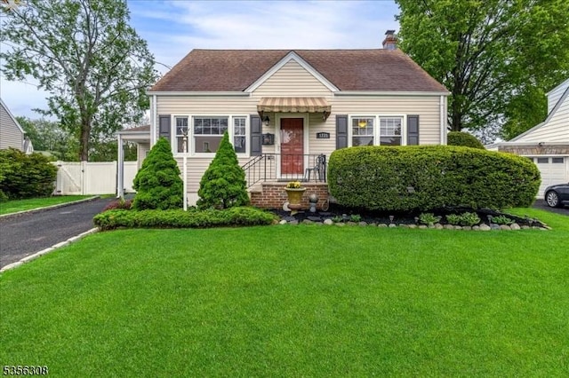 view of front of home with driveway, a chimney, roof with shingles, and a gate