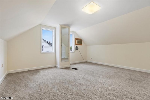 bonus room featuring light carpet, baseboards, and lofted ceiling