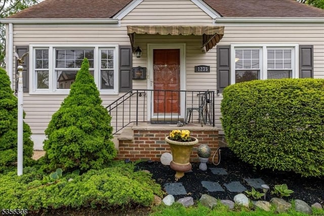 property entrance with roof with shingles