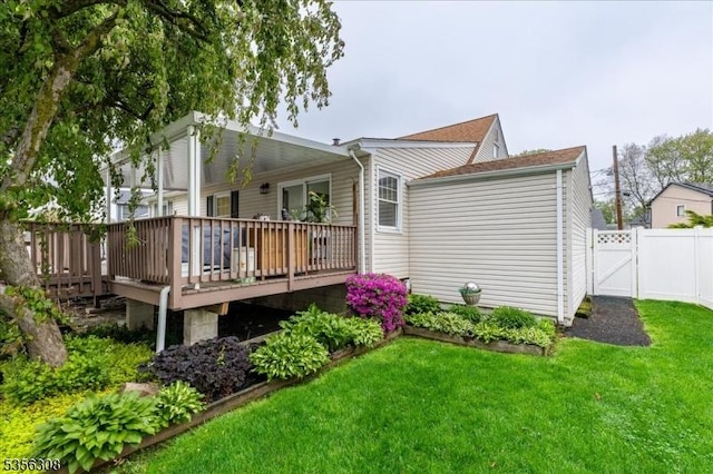 rear view of property with a wooden deck and a gate