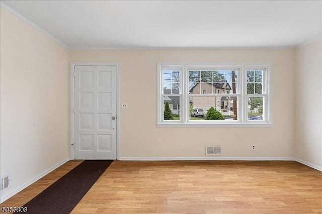 unfurnished room with light wood-style flooring, baseboards, and crown molding