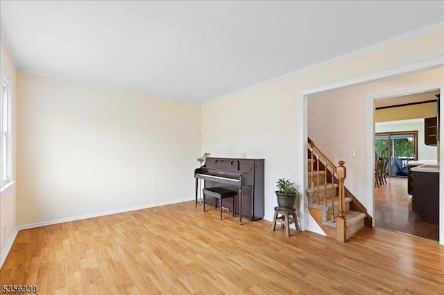 living area with light wood-style floors, stairway, ornamental molding, and baseboards