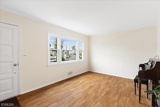 unfurnished room featuring light wood-type flooring and baseboards