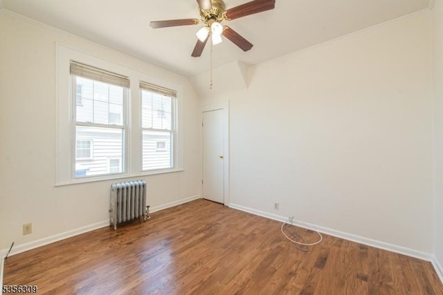 unfurnished room with radiator, baseboards, wood finished floors, and ceiling fan