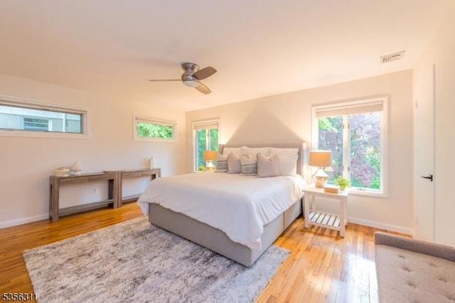 bedroom with light wood-style flooring, baseboards, and ceiling fan
