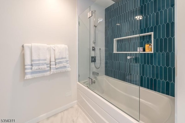 full bath featuring baseboards, shower / bath combination with glass door, and marble look tiles