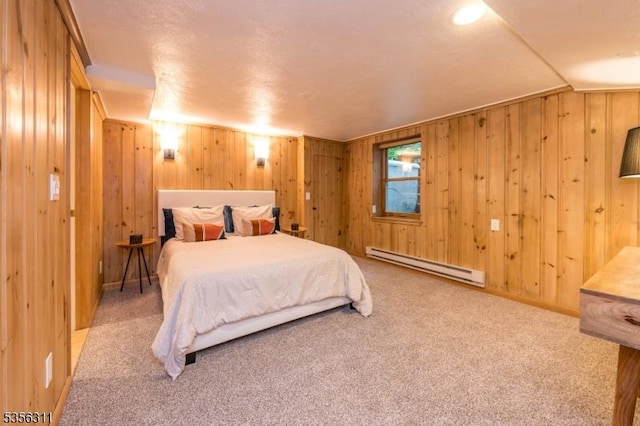 bedroom with a baseboard radiator, wood walls, carpet flooring, and lofted ceiling