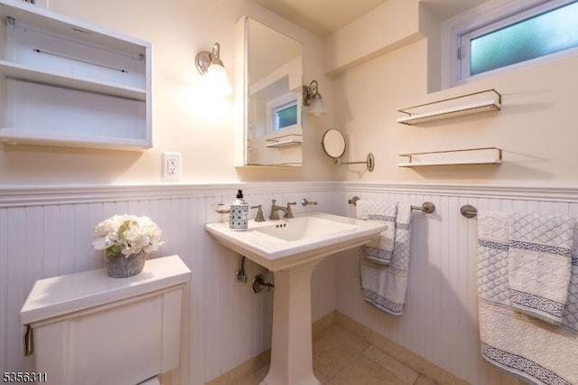 bathroom featuring wainscoting, toilet, and tile patterned flooring