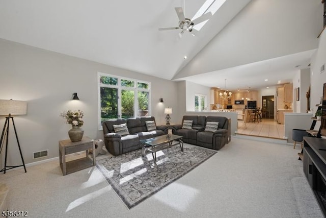 living area featuring light carpet, high vaulted ceiling, a chandelier, a ceiling fan, and recessed lighting