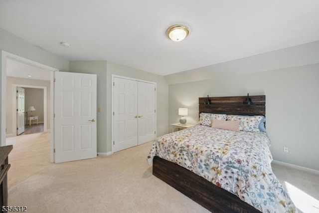 bedroom featuring light carpet, baseboards, and a closet