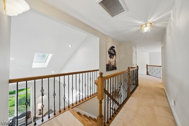 corridor with a skylight, recessed lighting, baseboards, carpet floors, and an upstairs landing
