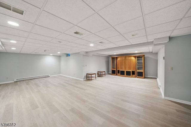 finished basement featuring a baseboard heating unit, baseboards, wood finished floors, a paneled ceiling, and recessed lighting