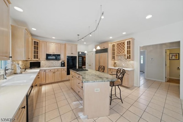 kitchen with light brown cabinets, a sink, a kitchen bar, light tile patterned floors, and recessed lighting