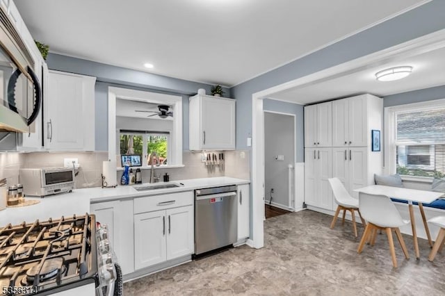 kitchen with stainless steel appliances, a sink, light countertops, decorative backsplash, and recessed lighting