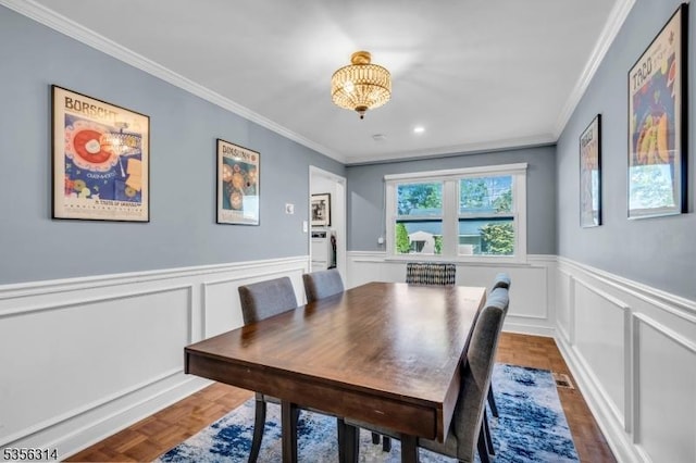 dining area with crown molding, wainscoting, a chandelier, a decorative wall, and recessed lighting