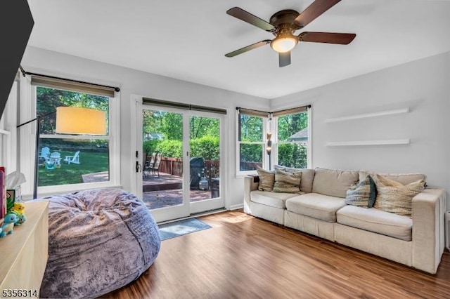 living area with wood finished floors, healthy amount of natural light, and a ceiling fan