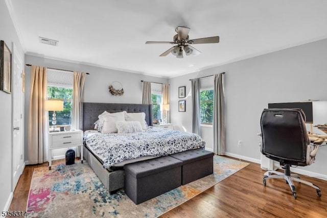 bedroom featuring multiple windows, wood finished floors, baseboards, and an office area