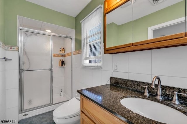 bathroom featuring a stall shower, toilet, and vanity