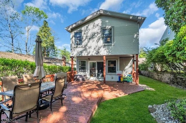 rear view of house featuring a lawn and outdoor dining area