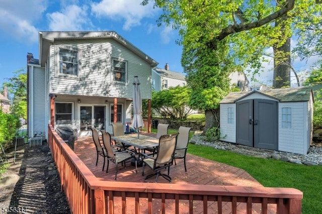 deck featuring a storage shed, an outdoor structure, and outdoor dining space