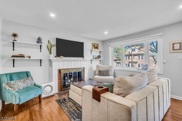 living room featuring wood finished floors, a fireplace, and recessed lighting