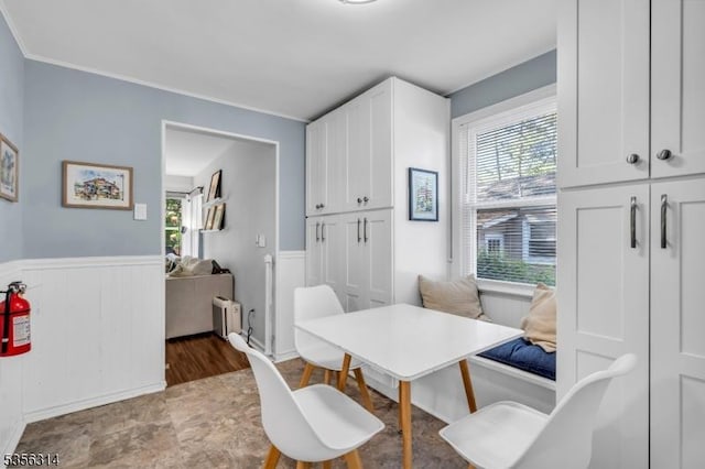 dining area with radiator, healthy amount of natural light, wainscoting, and ornamental molding