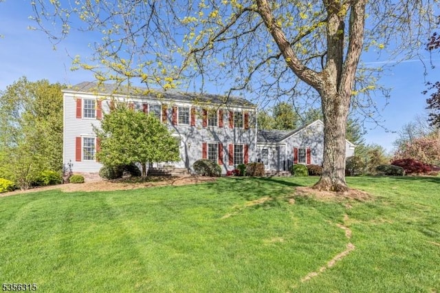 colonial inspired home with a front lawn
