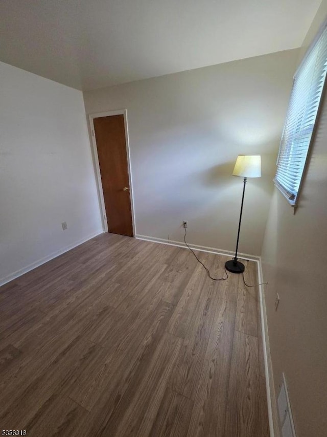 unfurnished room featuring wood finished floors and baseboards
