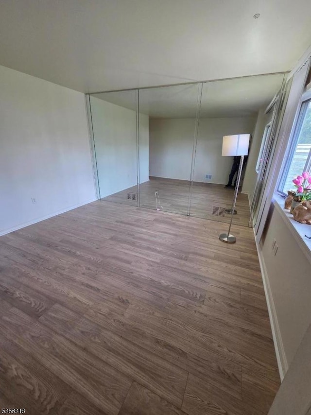 empty room with wood finished floors and baseboards