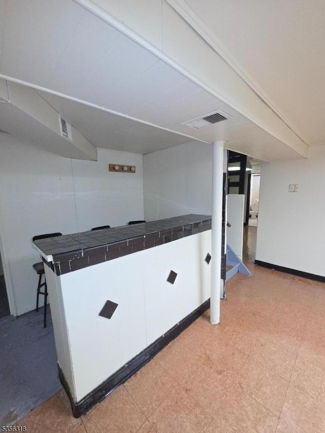 kitchen with tile counters, light floors, and baseboards
