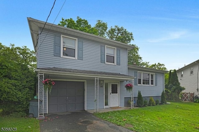 tri-level home featuring a front yard, an attached garage, and asphalt driveway