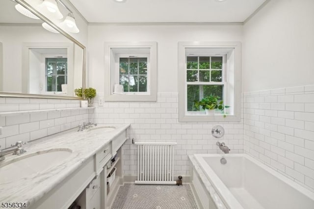 bathroom featuring radiator, tile walls, tile patterned flooring, a bath, and ornamental molding