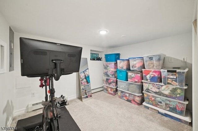 exercise area with carpet floors, a baseboard heating unit, and baseboards